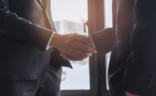 握手をしている2人のスーツ姿の男性