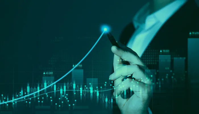 街の夜景とペンを手に持つスーツ姿の人物